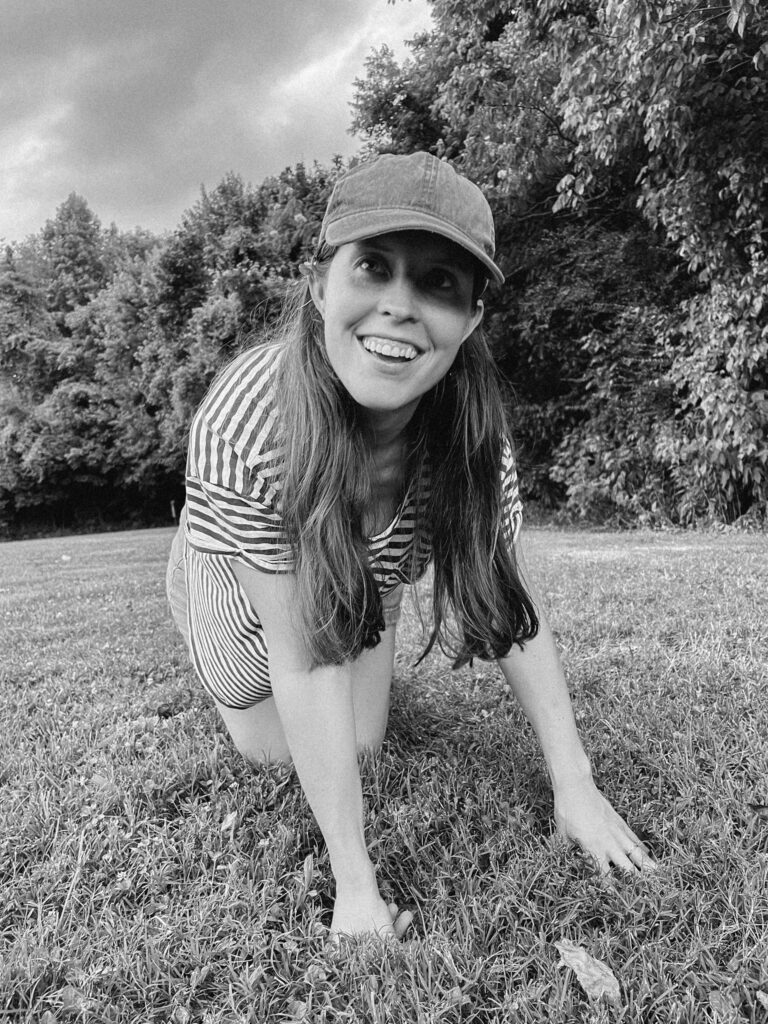 black and white image of girl with ball cap on and long hair.